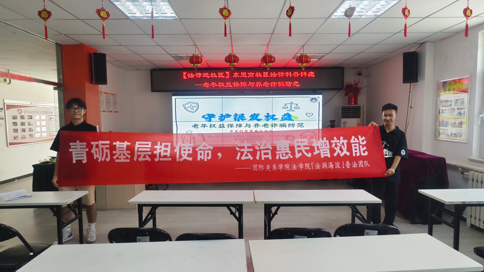 团队在东里南社区举红色横幅合影